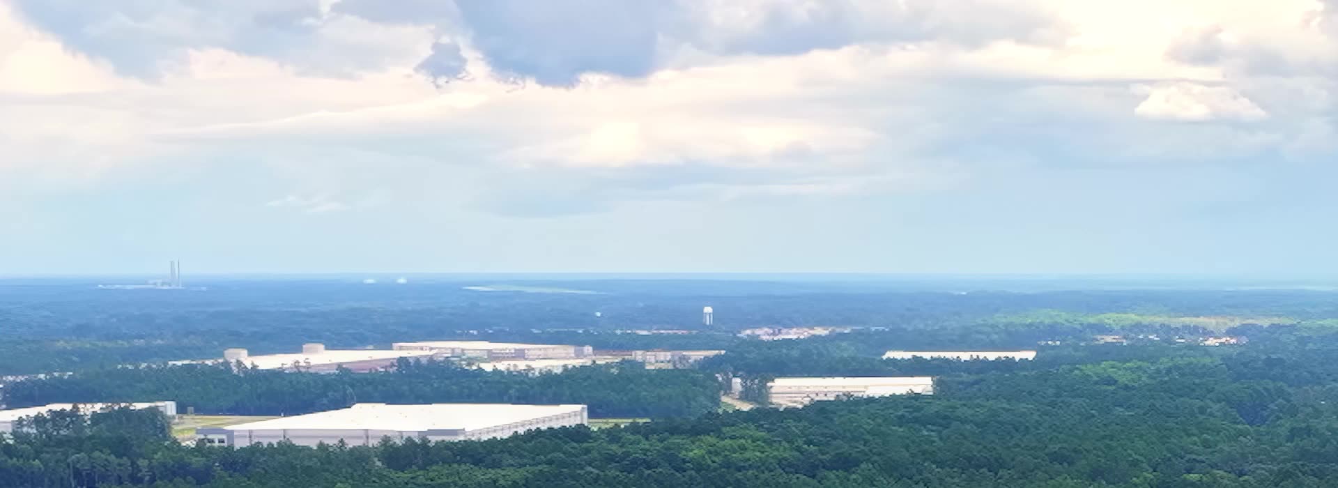 Aerial view across Effingham County forest toward nearby industry.