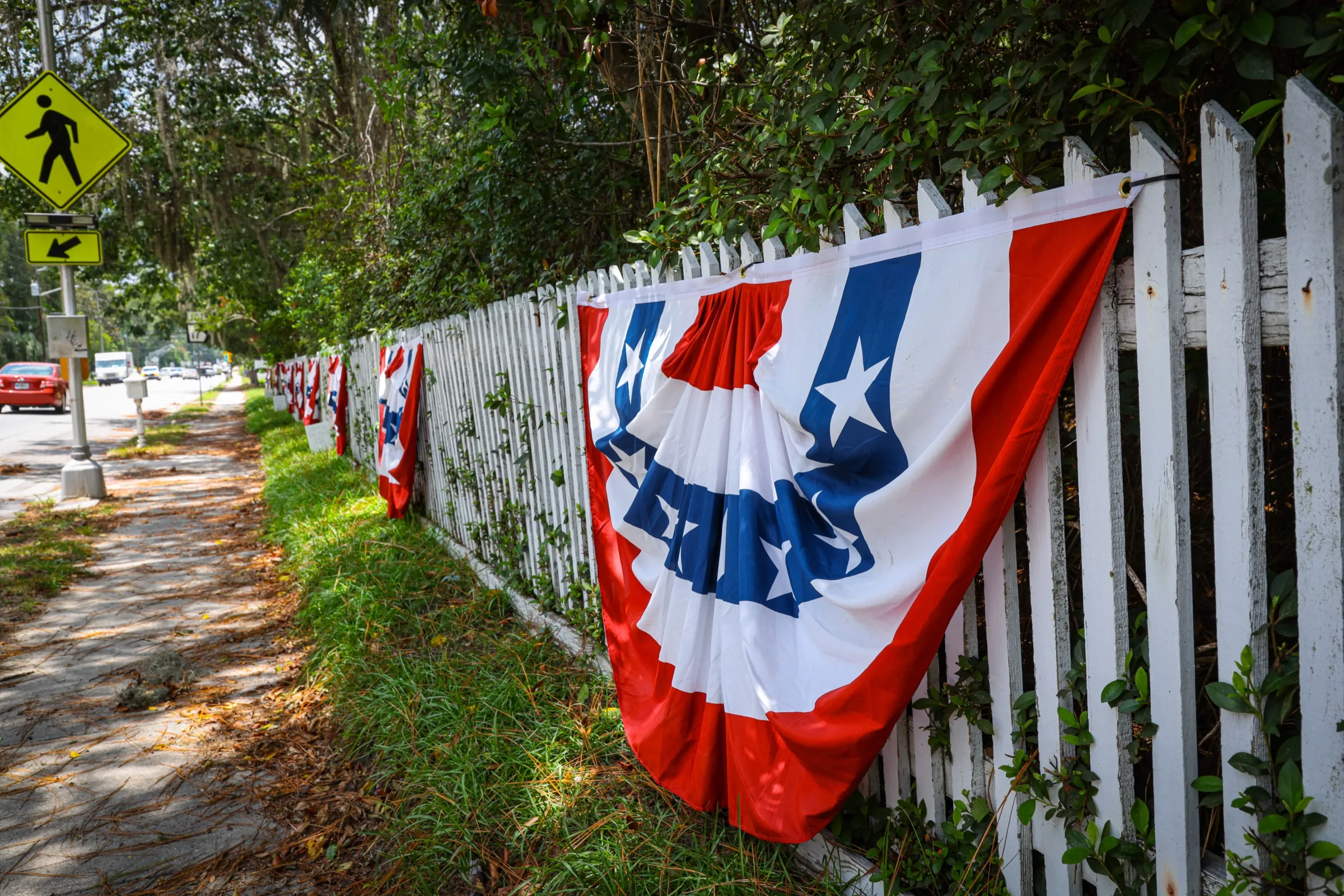 Patriotic bunting displayed along a white picket fence in Guyton.